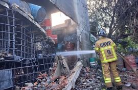 Bomberos de Villa Elisa realizan trabajo de enfriamiento ante avivamiento de llamas en depósito clandestino de combustible.
