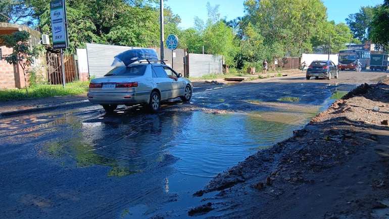 Los conductores cruzan en medio de charcos de agua servida.
