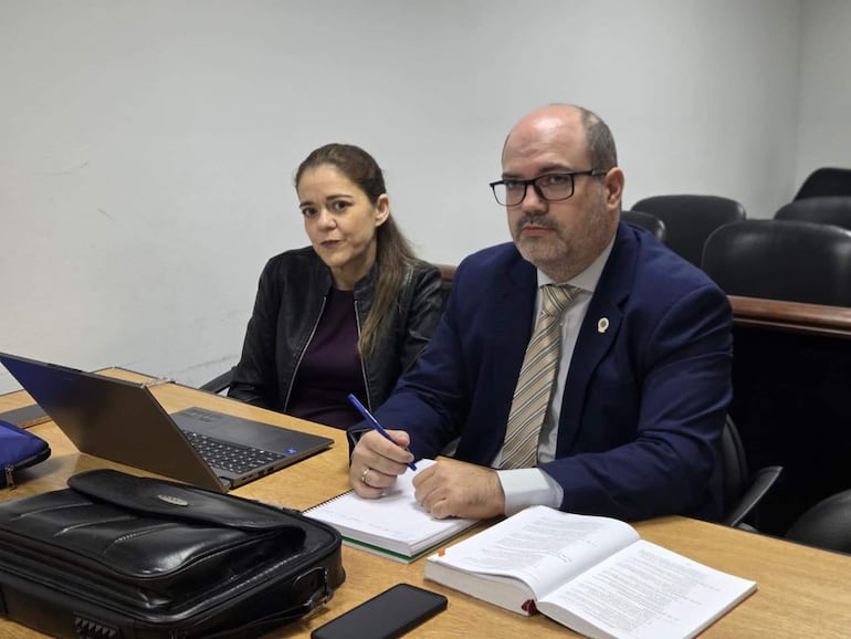 Verónica Mayor con chaqueta negra escucha atentamente, mientras Fernando Meyer, calvo y con gafas, toma notas en una mesa de reunión.