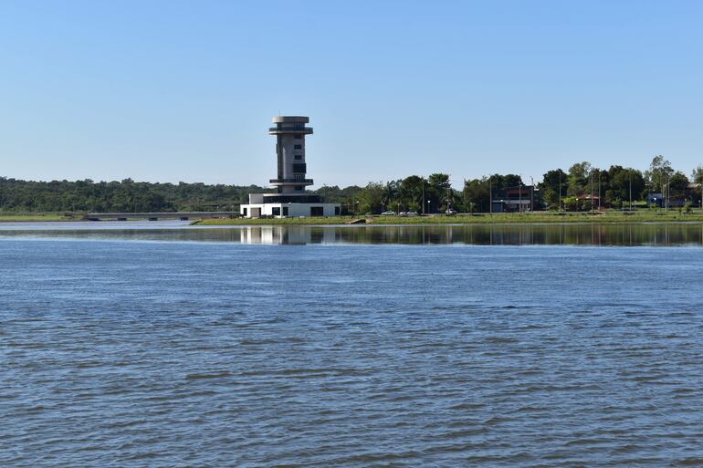 Paisaje del río Arroyo Poti'y con torre de observación moderna y edificaciones al fondo bajo un cielo despejado.