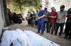 El Dr. Mohammed Abu Salmiya oficia las oraciones fúnebres por sus familiares asesinados el sábado (Getty)