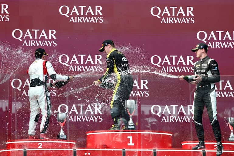 El paraguayo Joshua Duerksen (c), piloto de la escudería británica Invicta Racing, celebra la victoria en la carrera sprint de la primera fecha de la temporada 2026 de la Fórmula 2 de la FIA en el circuito de Albert Park, en Melbourne, Australia.