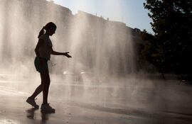 Una mujer se refresca en una fuente en Viena, Austria, durante una ola de calor.