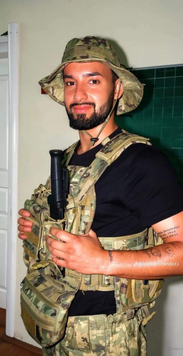 Néstor Adrián Barreto Fernández con uniforme militar camuflado, sosteniendo un arma durante una misión en Ucrania.