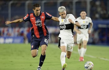 Gustavo Velázquez (i) de Cerro disputa un balón con Iván Leguizamón de Olimpia este sábado, en un partido de la Primera División de Paraguay entre Cerro Porteño y Club Olimpia en el estadio La Nueva Olla en Asunción (Paraguay).