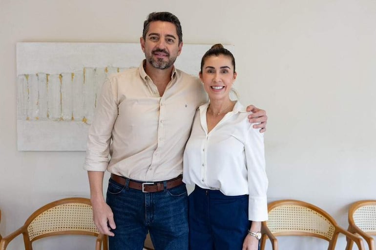 Pedro Alliana con camisa clara y jeans, Norma Belén Zárate de Monges en blusa blanca y falda azul, ambos sonriendo en un ambiente bien iluminado.