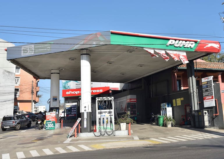 Estación de servicio Puma con expendedor de combustible y carteles promocionales en un entorno urbano.
