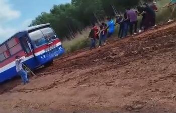 Pasajeros debieron estirar un colectivo con cuerdas para sacarlo del barro en Moisés Bertoni.