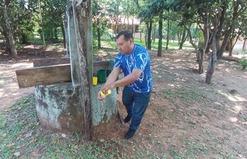 El profesor de grado, Milcíades Cabral, lavando los vasos con el agua de pozo.