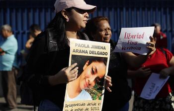 Una mujer muestra un cartel con una fotografía de Paola Delgado, desaparecida desde 2022 e hija de Verónica Delgado, detenida bajo el régimen de excepción, durante una protesta afuera de una sede judicial en San Salvador (El Salvador).