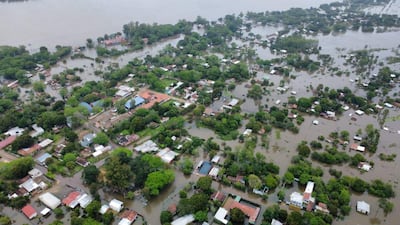 Paisaje aéreo de Ayola, donde numerosas casas quedan rodeadas de agua, con vegetación densa alrededor.