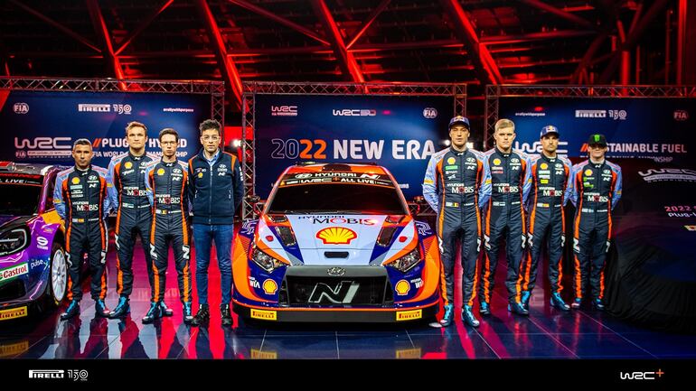 Los pilotos principales de Hyundai, Thierry Neuville y Ott Tänak, junto a sus demás compañeros rodean al flamante nuevo auto Rally1 para el WRC.