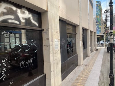 Calle vacía en Asunción con edificios de varios pisos y ventanas cubiertas de graffiti en un ambiente urbano silencioso.