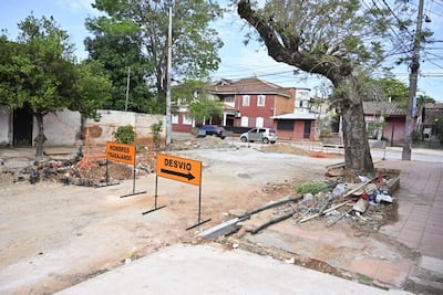 Carteles de advertencia en la calle indican trabajos en progreso y un desvío temporal para el tránsito.