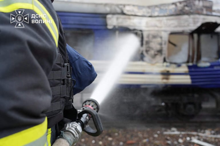 Bomberos intentan extinguir un incendio provocado por un ataque ruso contra un tren cerca de la frontera ucraniana con Polonia.