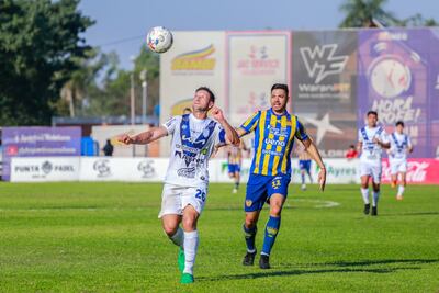 El zaguero del Sportivo Ameliano, Julio González Trinidad intenta retroceder el esférico ante la presencia cercana del delantero de Sportivo Luqueño, Walter González.