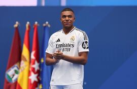 TOPSHOT - French forward Kylian Mbappe looks on during a first appearance as a Real Madrid player before fans at the Santiago Bernabeu Stadium in Madrid on July 16, 2024, after signing his new five-season contract. Still celebrating Spain's Euro 2024 triumph, Real Madrid fans have even more to cheer this July 16, 2024, as French superstar Kylian Mbappe is officially presented to a packed-out Santiago Bernabeu stadium. (Photo by Pierre-Philippe MARCOU / AFP)