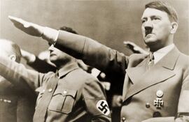 Adolf Hitler y Rudolph Hess, haciendo el saludo nazi. Hess tiene un brazalete con la esvástica.