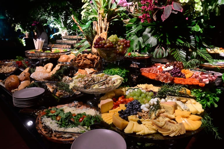 Mesa de quesos, jamones y acompañamientos para la previa en el sector de los adultos.