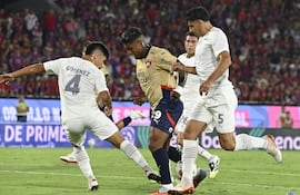 El extremo colombiano de Cerro Porteño, Harold Santiago Mosquera intenta avanzar entre los zagueros de Libertad, Néstor Giménez y Diego Viera.