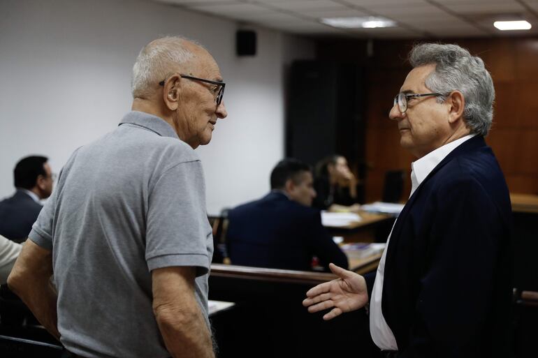 El excomisario de la Policía de Paraguay, Manuel Alcaraz (i), habla con Raúl Monte Domecq (d), presunta víctima de tortura durante la dictadura de Alfredo Stroessner, en un juicio oral y público este martes.