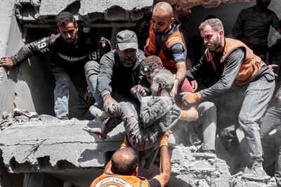 Rescatistas mueven a un niño que fue sacado con vida de entre los escombros de un edificio de cuatro pisos destruido por un bombardeo israelí el pasado 26 de octubre en el norte de la Ciudad de Gaza.