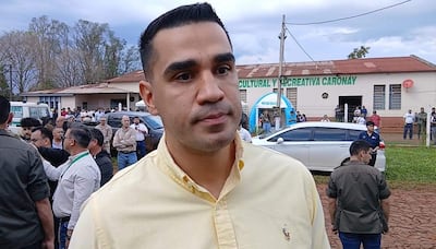Luis Fernando Bernal con camisa amarilla claro, expresión seria, rodeado de personas en un ambiente exterior frente a un edificio cultural.