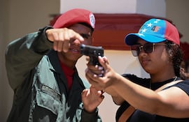 Un miembro de la Guardia Presidencial instruye a un recluta de la Milicia Nacional Bolivariana en el manejo de armas durante un ejercicio de entrenamiento en el fuerte militar 4F en Caracas.
