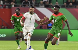 Riyad Mahrez (izq.), de Argelia, en acción contra Edmond Faycial Tapsoba (der.), de Burkina Faso, durante el partido de la fase de grupos de la Copa Africana de Naciones de la CAF 2025 entre Argelia y Burkina Faso, en Rabat, Marruecos.