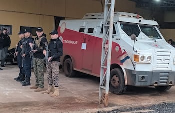 Cuatro integrantes de fuerzas de seguridad, uniformados y armados, en disposición atenta frente a un vehículo blindado en Santaní