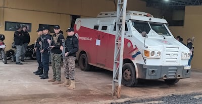 Cuatro integrantes de fuerzas de seguridad, uniformados y armados, en disposición atenta frente a un vehículo blindado en Santaní