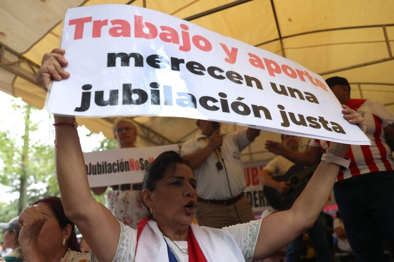 Una mujer sostiene un cartel durante una marcha este martes, en Asunción.
