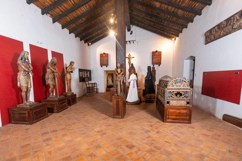 Sala del museo con esculturas de madera de personajes religiosos sobre pedestales, sin personas presentes.
