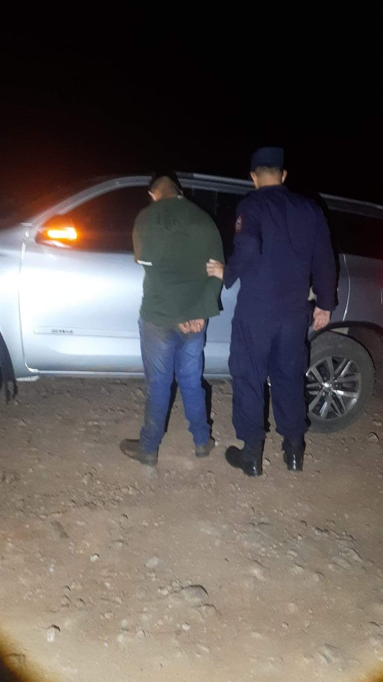 El detenido es custodiado por un agente policial cerca de la camioneta en la que transportaba la marihuana.