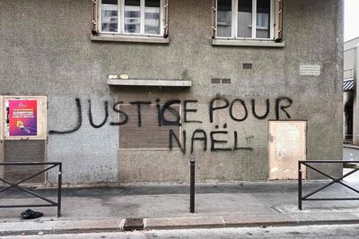 Un letrero que dice "Justicia para Nahel", en una casa al lado del edificio parcialmente incendiado (extremo derecho) de la Brigada de Asistencia para Personas sin Hogar (BAPSA) en París, luego de disturbios dos días después de un La policía le disparó a quemarropa a un niño de 17 años en el pecho en Nanterre, un suburbio al oeste de París.