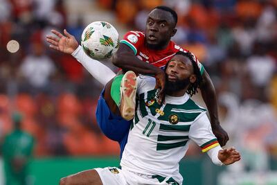 Muhammed Sanneh, defensor de Gambia, rechaza el balón trepando sobre el cuerpo del camerunés Georges-Kevin Nkoudou.