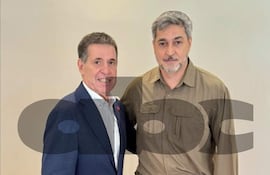Cartes con traje oscuro y camisa blanca, y Abdo Benítez en camisa oliva, ambos sonriendo y escuchándose atentamente en un fondo claro.