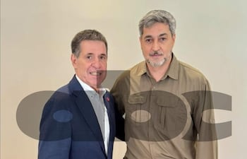 Cartes con traje oscuro y camisa blanca, y Abdo Benítez en camisa oliva, ambos sonriendo y escuchándose atentamente en un fondo claro.