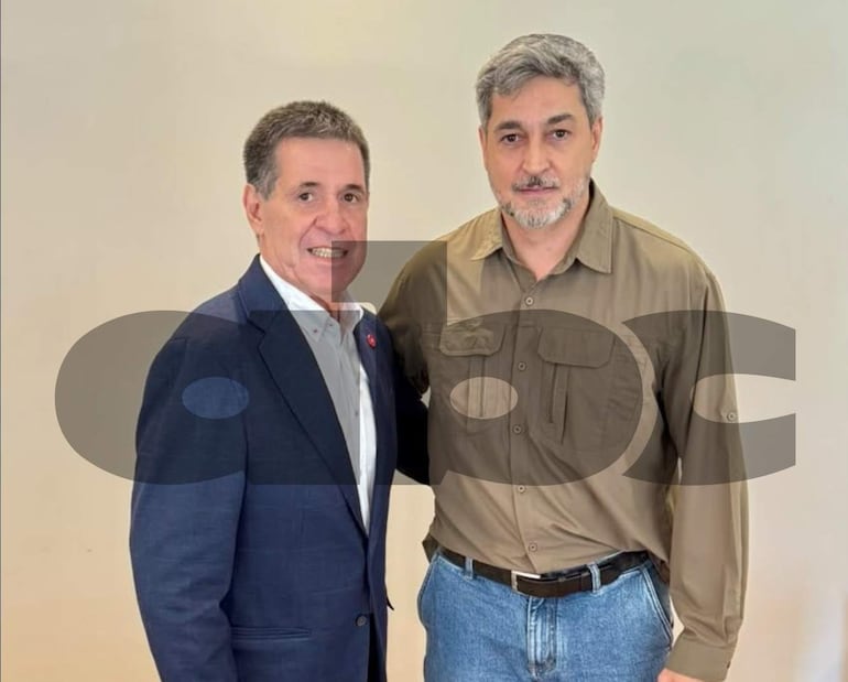 Cartes con traje oscuro y camisa blanca, y Abdo Benítez en camisa oliva, ambos sonriendo y escuchándose atentamente en un fondo claro.