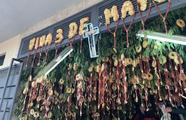 Decoraciones festivas con el texto 'Viva 3 de Mayo' y una cruz iluminada en un ambiente festivo y alegre.