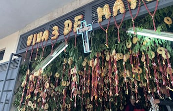 Decoraciones festivas con el texto 'Viva 3 de Mayo' y una cruz iluminada en un ambiente festivo y alegre.