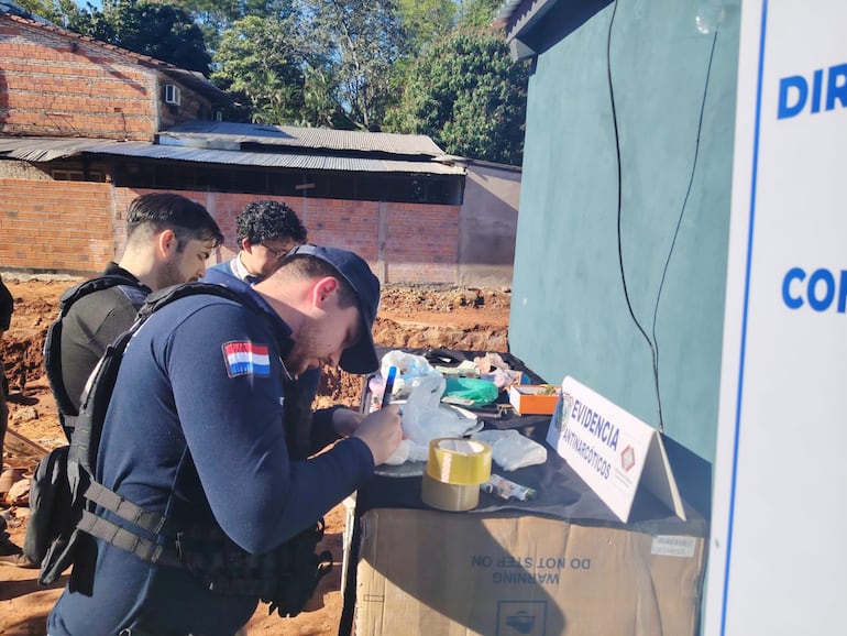Los agentes toman nota de todo lo que se encontró en poder de los sospechosos.