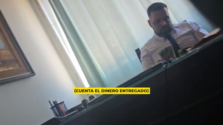 El falso abogado cuenta el dinero recibido por la denunciante de la estafa.