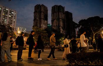 Personas dejan tributos florales para las víctimas del incendio en el complejo residencial Wang Fuk Court, en el distrito de Tai Po de Hong Kong (China).