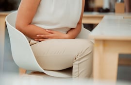 Una mujer se retuerce de dolor