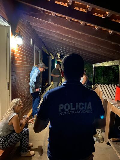 Agentes de  policía conversan con las víctimas del violento golpe. Los criminales aparentemente huyeron a pie de la casa.