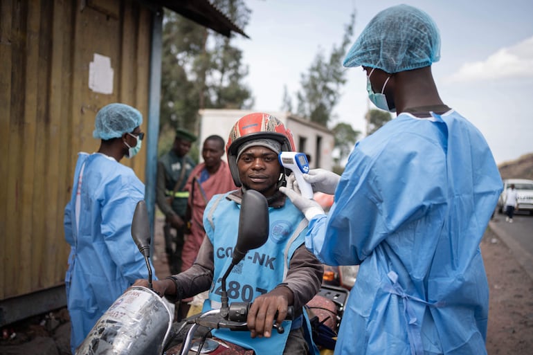 Trabajadores de salud revisan las temperaturas corporales de transeúntes cerca de la ciudad de Goma, en la República Democrática del Congo.