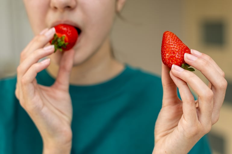 Mujer come frutillas.