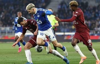 El delantero paraguayo del Estrasburgo, Julio Enciso, lucha por el balón con el defensor Maxime Colin y el centrocampista Alpha Toure, durante el partido de la L1 francesa entre el RC Estrasburgo y el FC Metz en el Stade de la Meinau en Estrasburgo, en el este de Francia.