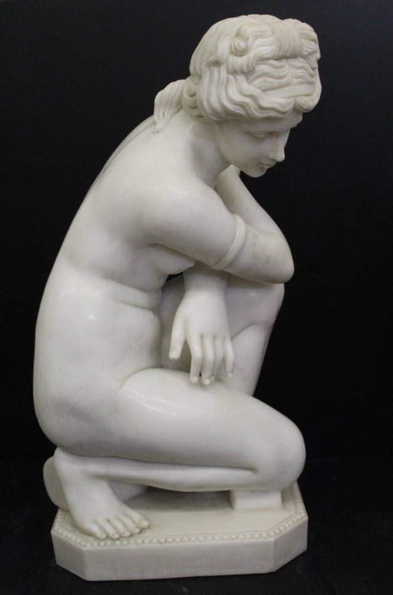 Un visitante de rodillas frente a una obra de arte en la exposición de mitos griegos, en un ambiente solemne.